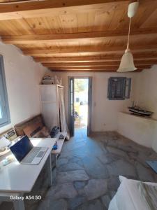 a room with a kitchen with a laptop on a desk at Charmante maison cycladique traditionnelle in Faros