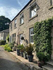 a brick building with potted plants in front of it at Middle Cottage in Middleham