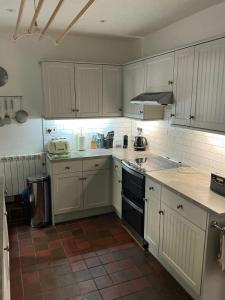 a kitchen with white cabinets and a stove top oven at Middle Cottage in Middleham +6 photos