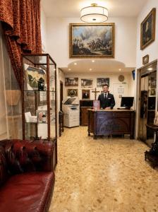 a man standing at a desk in a room at Hotel Chopin in Fiumicino +131 photos