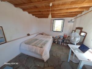 a bedroom with a bed and a desk with a laptop at Charmante maison cycladique traditionnelle in Faros