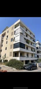 a large building with a car parked in front of it at Haidar house in Baabda