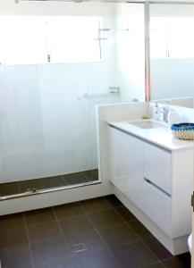 a white bathroom with a sink and a shower at Contemporary Cove - Quindalup in Quindalup