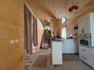 a kitchen with a staircase in a wooden house at Natas Saxli in K'vemo Zhoshkha