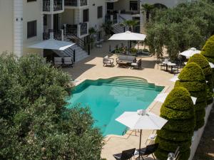 Draufsicht auf ein Schwimmbad mit Sonnenschirmen und Liegestühlen in der Unterkunft Maryan in Limenas