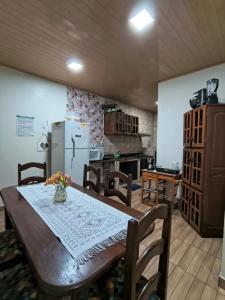 a kitchen with a table and chairs and a refrigerator at Casa Privativa com Piscina, Churrasqueira, Wi-Fi e Ar-Condicionado em Manaus in Manaus