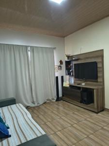 a living room with a flat screen tv on a wall at Casa Privativa com Piscina, Churrasqueira, Wi-Fi e Ar-Condicionado em Manaus in Manaus