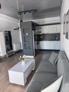 a living room with a gray couch and a table at Cozy Crib 2 in Mamaia Sat/Năvodari