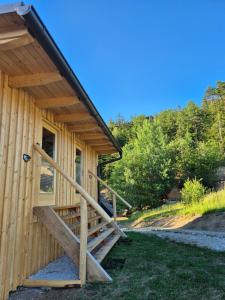 a wooden cabin with a wooden ramp leading to a door at Glamping Gril in Ljubno