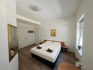 a white bedroom with a bed and a mirror at Wald Villa Üssbach in Alf