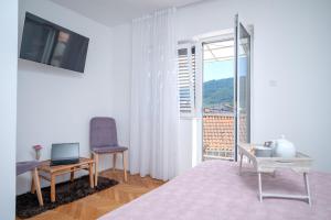 a living room with a laptop on a table and a window at Guesthouse Wish in Stari Grad