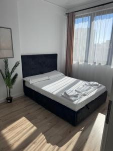 a bed in a bedroom with a large window at Cozy Crib 2 in Mamaia Sat/Năvodari