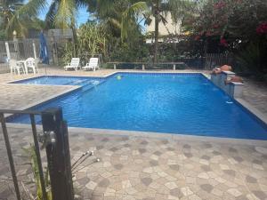 a swimming pool in a yard with chairs at Red Coral Apts in Coroa Vermelha +8 photos