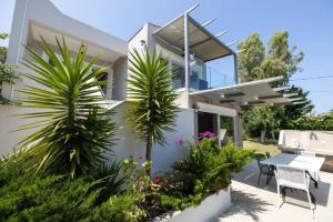 a house with palm trees in a yard at Gyra Villas - Seaview Villa Fivos with private pool in Lefkada