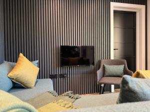a living room with a couch and a tv and a chair at Forest Lodges in Betws-y-coed