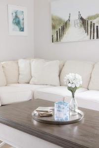 a coffee table with a vase of flowers and a couch at Poolside Palms - Team Joseph Ellen in Jacksonville Beach +102 photos