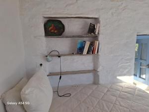 a white room with a couch and a lamp and books at Ancienne ferme traditionnelle in Katavatí