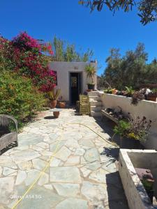 a stone patio with chairs and flowers in front of a building at Ancienne ferme traditionnelle in Katavatí