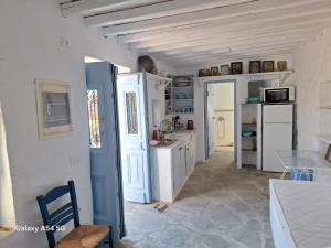 a kitchen with white cabinets and a blue refrigerator at Ancienne ferme traditionnelle in Katavatí