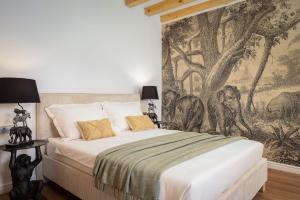 a bedroom with a large bed with a wall mural at Palazzo Viridis Heritage Hotel in Milna