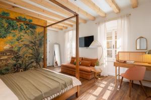 a bedroom with a canopy bed and a desk at Palazzo Viridis Heritage Hotel in Milna