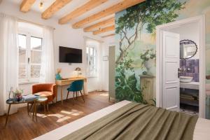 a bedroom with a bed and a painting on the wall at Palazzo Viridis Heritage Hotel in Milna