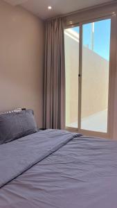 a bedroom with a bed and a large window at سفانه in Unayzah