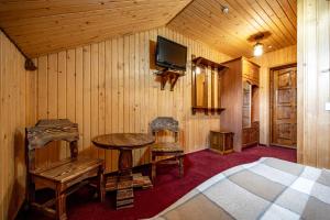 a bedroom with a bed and a table and a tv at Марина in Bukovel