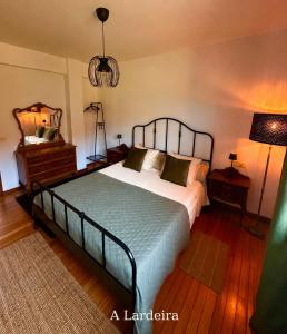 ein Schlafzimmer mit einem Bett, einer Kommode und einer Lampe in der Unterkunft Lar Do Lago - Rooms in Negreira