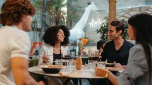 a group of people sitting around a table in a restaurant at Hotel Indigo Florence by IHG in Florence