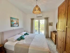 a bedroom with a large bed and a chandelier at Villa in Skiathos in Skiathos +32 photos