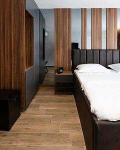 ein Schlafzimmer mit einem Bett und einem Holzboden in der Unterkunft SOLO Hotel in Prizren