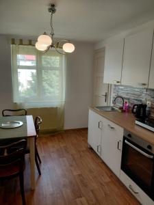 a kitchen with white cabinets and a table and a window at Apartment Robin in Karlovy Vary