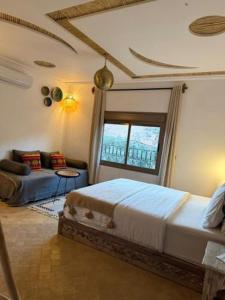 a bedroom with a bed and a couch at Dar Rihana Dadès in Aït Idaïr