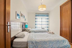 a bedroom with two beds and a window at Brisa Do Mar Moura Beach in Quarteira +20 photos