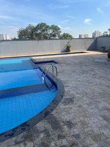a swimming pool with blue tiles on the ground at Seu espaço in Sorocaba