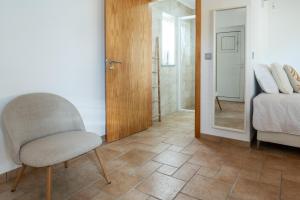 a bedroom with a chair and a bed and a mirror at Quinta da Barradinha in Odemira +86 photos