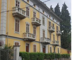 a yellow building with balconies on the side of it at Ca di Biella, mansarda di charme. in Biella