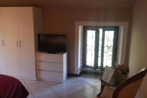 a living room with a television and a window at Ca di Biella, mansarda di charme. in Biella