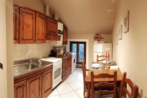 a kitchen with wooden cabinets and a table and a sink at Ca di Biella, mansarda di charme. in Biella