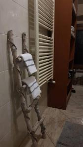 a towel rack in a bathroom with a pile of towels at Ca di Biella, mansarda di charme. in Biella +28 photos