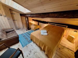 an attic room with a bed and a couch at Casa Piazzo Due in Brusio