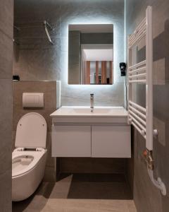 ein Badezimmer mit Waschbecken, Toilette und Spiegel in der Unterkunft SOLO Hotel in Prizren + 65 Fotos