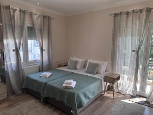 a bedroom with a bed with two towels on it at MoSta Sunset in Litochoro