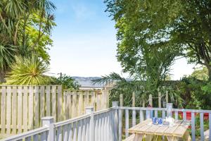 a white picket fence with a wooden table and a wooden table at 2 Bed in Brixham oc-bx081 in Brixham