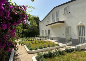 a garden in front of a building with purple flowers at EmmeBi Appartamenti in Acquedolci
