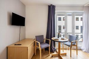 a living room with a table and chairs and a desk at Apartments Lübeck in Lübeck