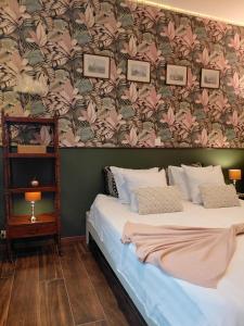 a bedroom with a large bed with a floral wallpaper at B&B Fleur in Schoten