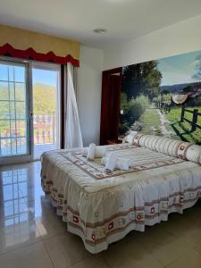 a large bed in a room with a large window at Casa Rodiño in Meaño