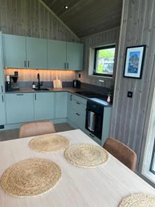 a kitchen with a table with four chairs and a counter at Lofoten Arctic Cabin in Sørvågen